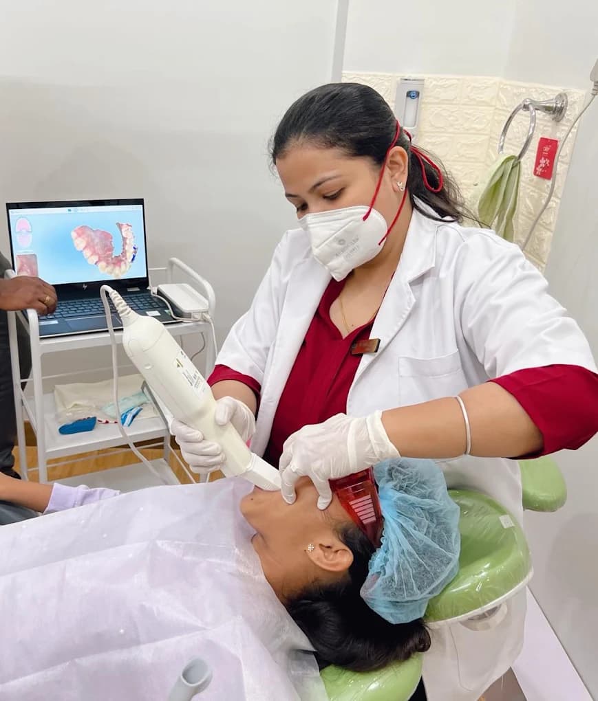 Dentist using a handheld digital dental scanner on a patient in the dental chair